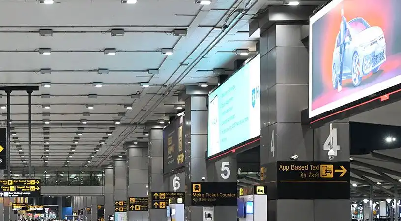 Airport terminal interior with directional signage and digital advertising screens