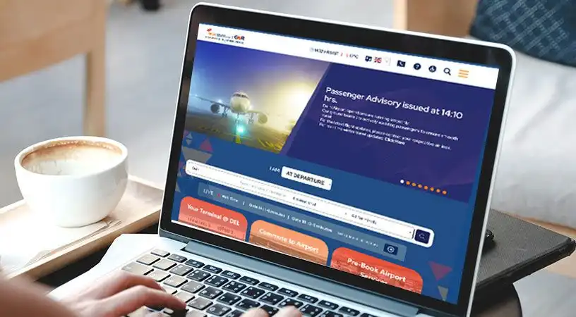 Laptop displaying Delhi Airport website on screen
