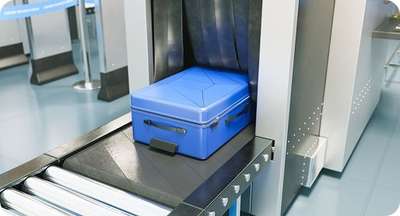 Suitcase passing through baggage scanner