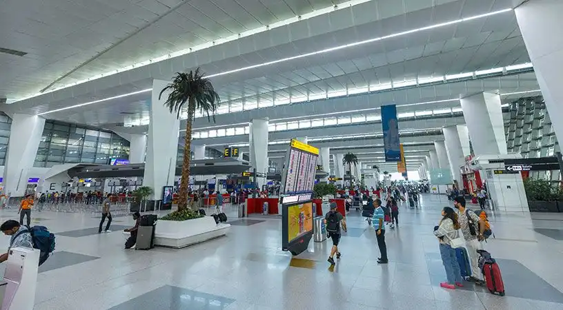 Airport concourse with passengers and central digital information display