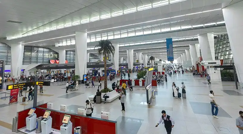 Wide view of airport terminal with passengers and retail areas